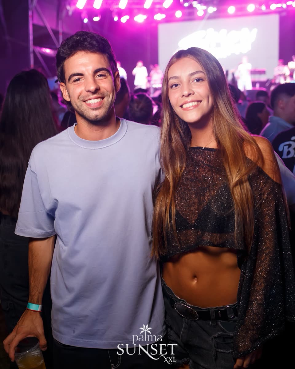 Una pareja sonriendo frente al escenario de Palma Sunset